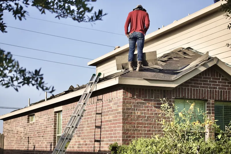 Professional roofer working on a residential roof in Fort Dix